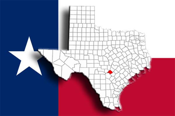 Comal County highlighted with the Texas flag in the background